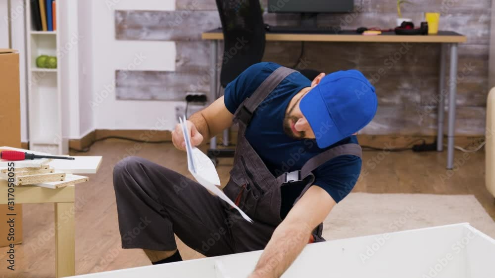 Confused worker in overalls reading instructions Confused worker in overalls reading instructions