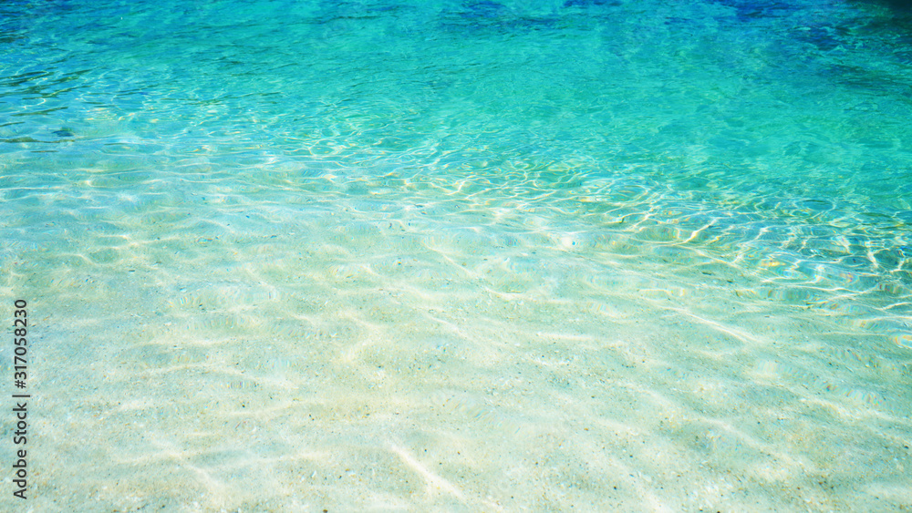 Texture of crystal clear water sea and soft gradient blue color, Beautiful tropical beach summer background.