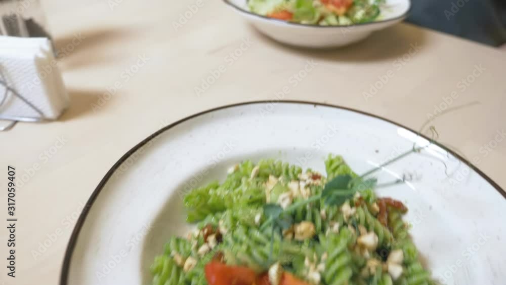 a vegetarian lunch. vegetable salad and pasta with a green sauce. a vegetarian lunch. vegetable salad and pasta with a green sauce.