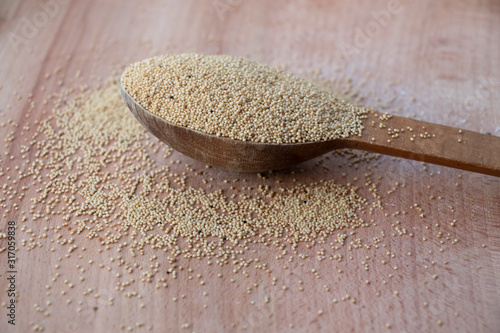 Amaranth seeds on a wooden board. Wooden spoon on a white background. Healthy food, best breakfast. Food.