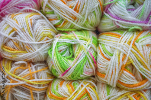 Multicolored wool balls of yarn. Background of colored yarn balls. Embroidery. Knitting.