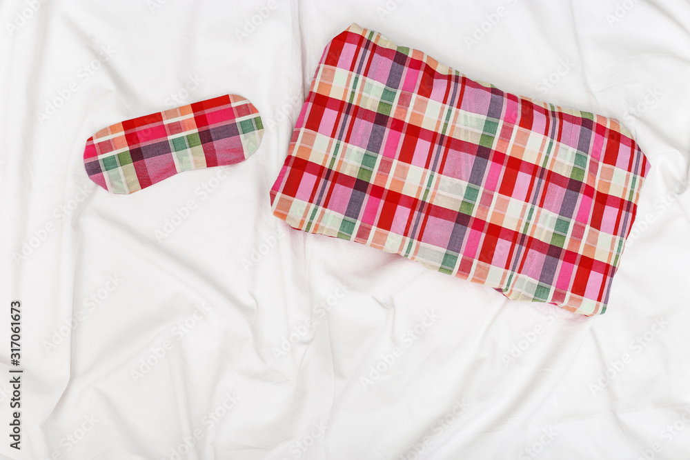 Pillow and Eye mask for sleeping on white cotton bedsheet. Healthy sleep. Top view. Flat lay. Pillow and Eye mask for sleeping on white cotton bedsheet. Healthy sleep. Top view. Flat lay.