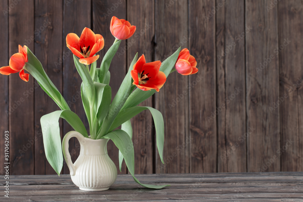 tulips in vase on dark wooden background tulips in vase on dark wooden background