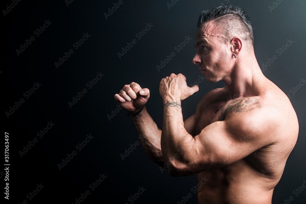 Male bodybuilder with an athletic build on a dark background.athlete, exercise, health, power, strength, man, box