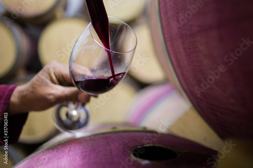 Photo Close up image of a wine sample being collected by a wine maker in a cellar with