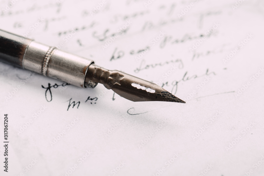 Fototapeta premium Fountain pen on an ancient handwritten letter. Old story. Retro style.