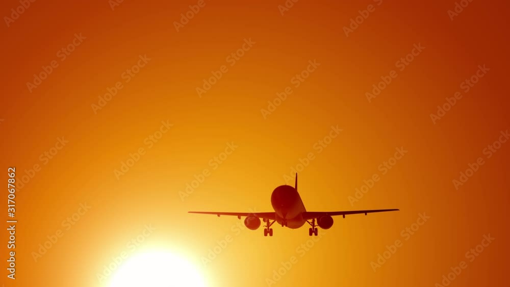 A large passenger plane takes off against the background of a sunset. Orange backgrand..Super slow motion.