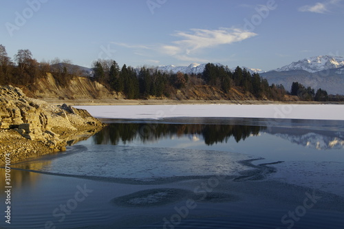 Blick über den winterlichen Forggensee in Richtung Alpen