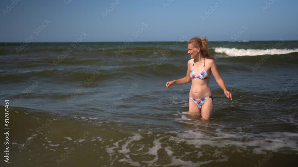 Young, fit and attractive girl catch sea waves in colorful bikini. Pretty woman Young, fit and attractive girl catch sea waves in colorful bikini. Pretty woman