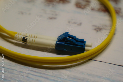 Wallpaper Mural closeup of yellow optical fiber network cable on wooden table background Torontodigital.ca