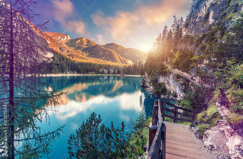 Wonderful sunrise view of Braies lake. Dramatic Unusual Scene. Colorful Sky over lago di Braies in Dolomites Alps. Awesome Alpine Highlands during sunset. Amazing nature Landscape at Summer Day - obrazy, fototapety, plakaty 