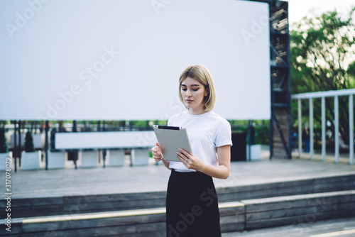 Фотография Elegant woman interacting with tablet near scene