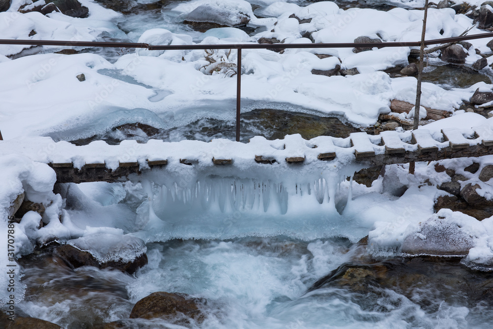 frozen bridge with icicles in winter