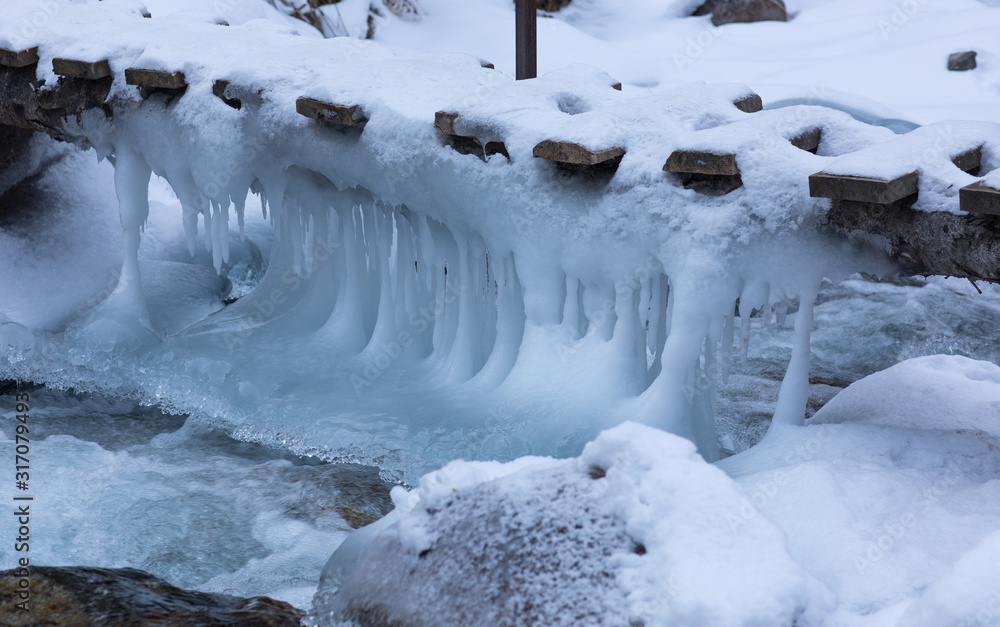 frozen bridge with icicles in winter