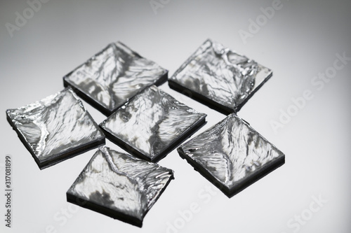 Pieces of polycrystalline silicon on grey background. photo