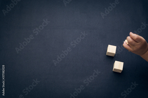 Wooden cube alphabet closeup and children hands on black background. Selective focus and education concept