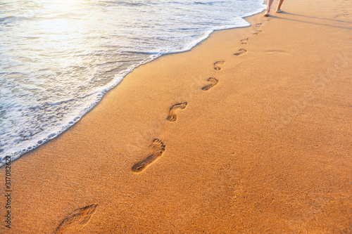 Fototapeta Naklejka Na Ścianę i Meble -  beach, wave and footprints at sunset time