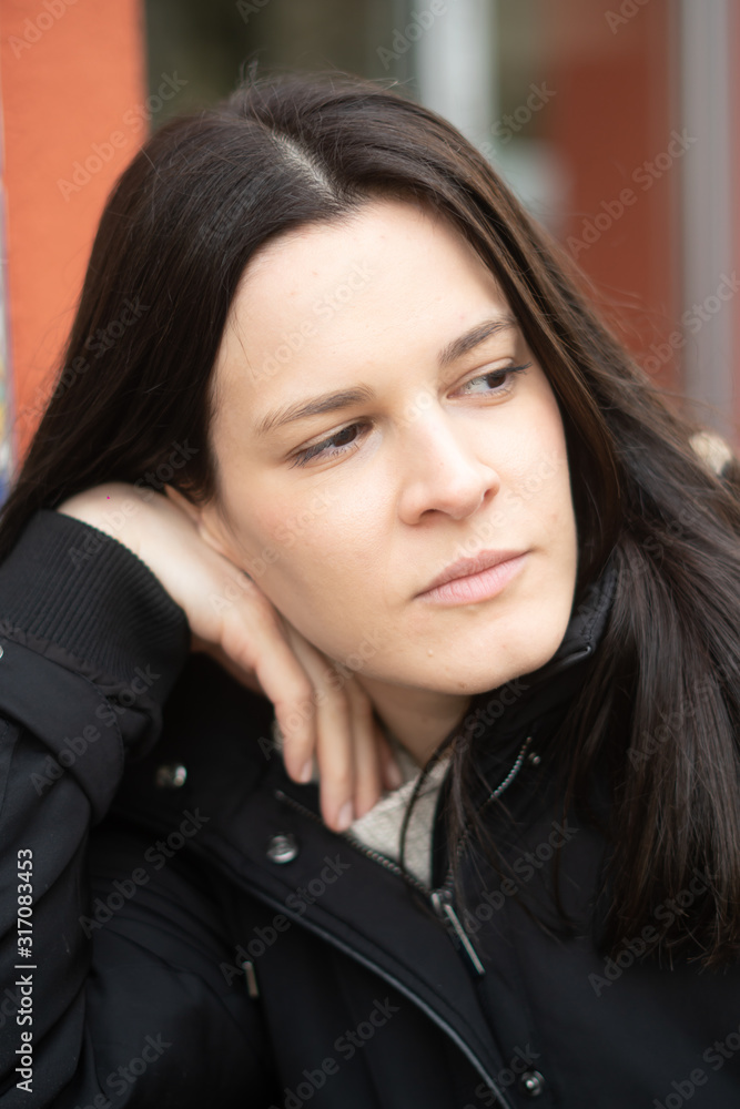 Close-up portrait of a pensive and lonely young brunette woman with a dreamy gaze Close-up portrait of a pensive and lonely young brunette woman with a dreamy gaze