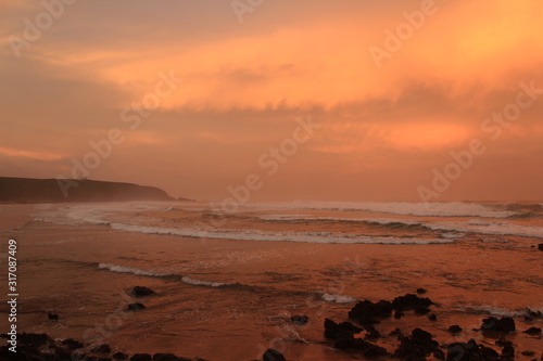 dramatic sunset on the beach with orange clouds