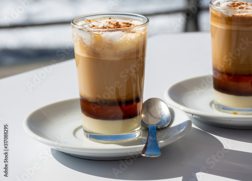 Special coffee of Canary islands, sweet barraquito coffee with layers and alcohol served in glass photo