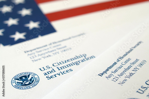 Envelopes with letter from USCIS on United States flag from Department of Homeland Security