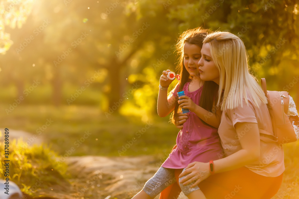 Happy mother with child enjoying together in sunny nature Happy mother with child enjoying together in sunny nature