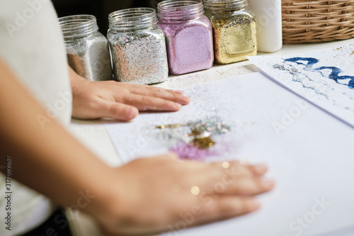 Containers with different colour of glitter for creating art work