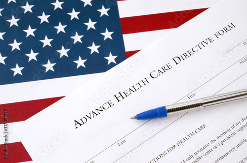 Advance health care directive blank form and blue pen on United States flag