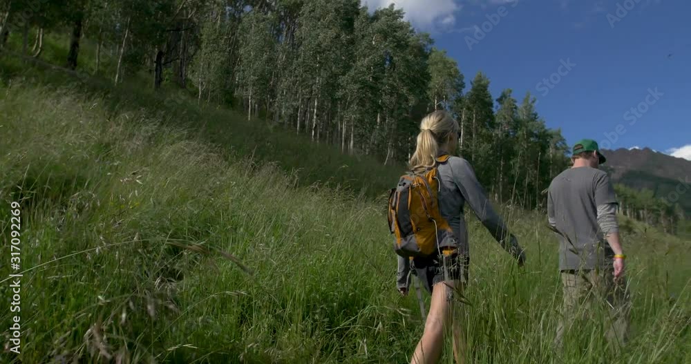 Couple Hiking Colorado Mountain Trail with Dog Tall Grass Couple Hiking Colorado Mountain Trail with Dog Tall Grass