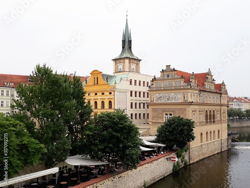 Vltava riverside with Smetana Museum and Clock Tower in Prague, Czech Republic, seen from the Charles Bridge.
