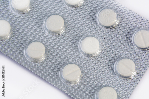 White tablets in blister packs, shallow depth of field. Close-up of medicines, background, concept.