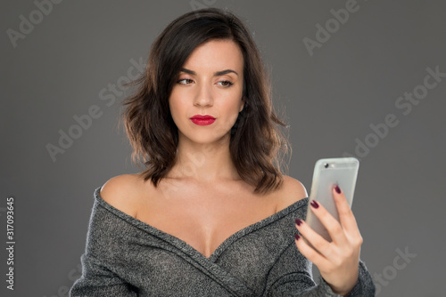 Portrait of a young woman of 30-35 years of model appearance, reading messages on the phone. Women's emotions in the conversation, the psychological portrait.