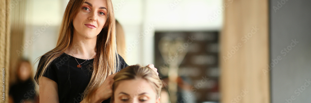 Fototapeta premium Professional Hairdresser Make Hairstyle to Client. Woman Hairstylist Picking Haircut for Young Girl. Stylist Holding Long Hair of Female Customer. Modern Beautician Styling Hair for Beauty Model