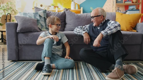 Portrait of grandfather and grandson putting on eyeglasses smiling having fun at home. Happy family, relationship with children and childhood concept. photo