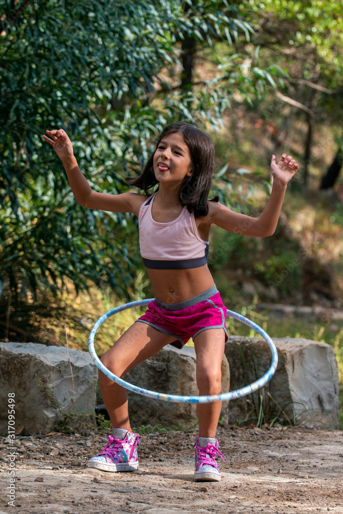 Fotka „Cute girl posing with hula hoop“ ze služby Stock | Adobe Stock