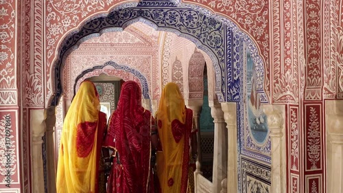 India, Rajasthan, Jaipur, Samode Palace, ladies wearing colourful Saris in ornate passageway - Model released photo