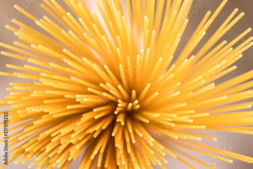 Raw spaghetti in hand, top-down view. Selective focus.