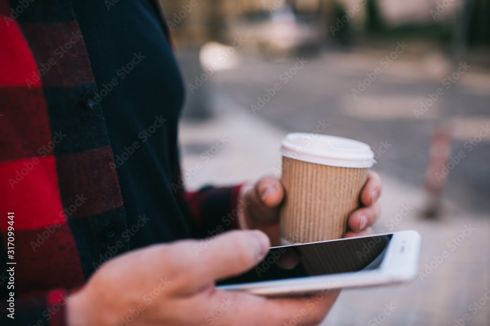 Faceless man using smartphone having coffee cup Faceless man using smartphone having coffee cup