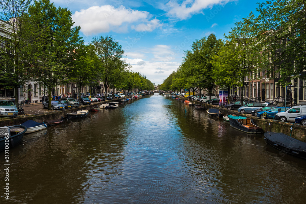 Beautiful View of  an Amsterdam canal with boats and buildings in the background