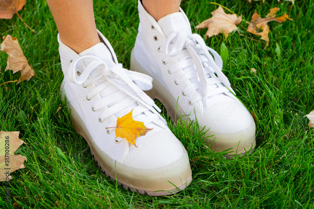 Legs of a girl in white boots. Autumn Park. Legs of a girl in white boots. Autumn Park.