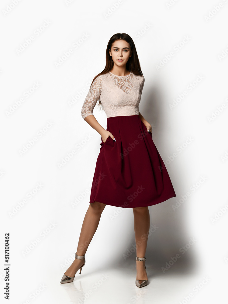 Young beautiful woman posing in new fashion casual red cherry winter dress skirt on white background Young beautiful woman posing in new fashion casual red cherry winter dress skirt on white background