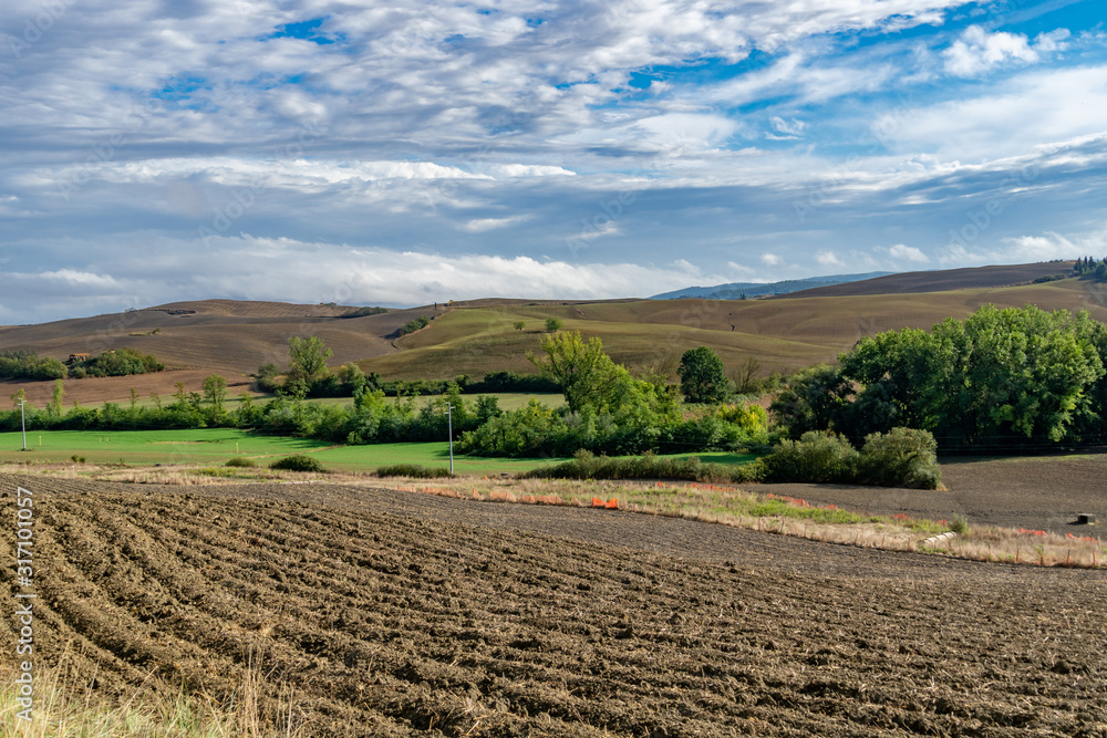 Tuscany landscape at gentle sunset light. Typical for the region tuscan farm, hills, vineyard. Italy, Europe Tuscany landscape at gentle sunset light. Typical for the region tuscan farm, hills, vineyard. Italy, Europe