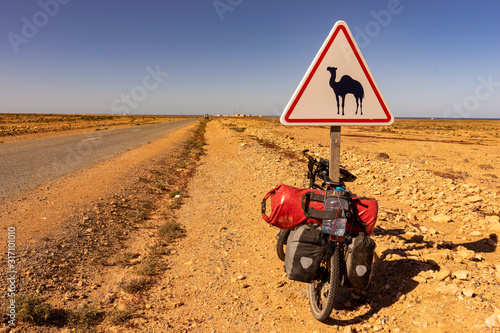 Camel street sign, a touring bike leaning against the post
