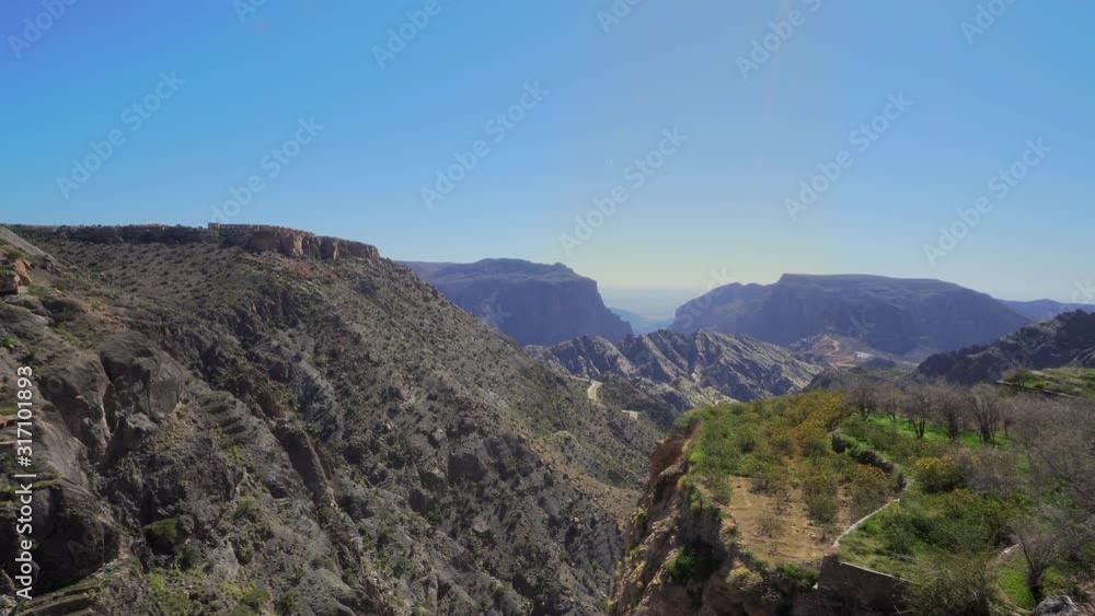 Young Foreign Female Tourist Enjoying the View of Omani Mountains at Jebel Akhdar Gorge in Al Hajar Range, Oman. Woman in Active Solo Travel in Middle East Countries Young Foreign Female Tourist Enjoying the View of Omani Mountains at Jebel Akhdar Gorge in Al Hajar Range, Oman. Woman in Active Solo Travel in Middle East Countries