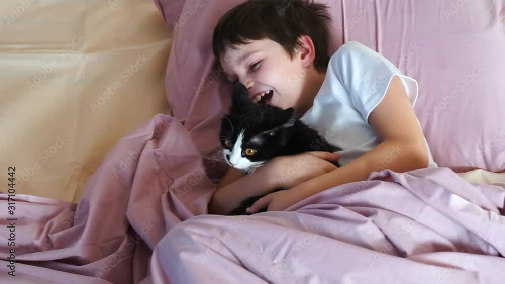 child boy sleeping together with a cat. close up. Cute child hugging, holding and petting kitten lying in bed. Fluffy black cat. Cozy morning at home. friendship and pet love. child boy sleeping together with a cat. close up. Cute child hugging, holding and petting kitten lying in bed. Fluffy black cat. Cozy morning at home. friendship and pet love.