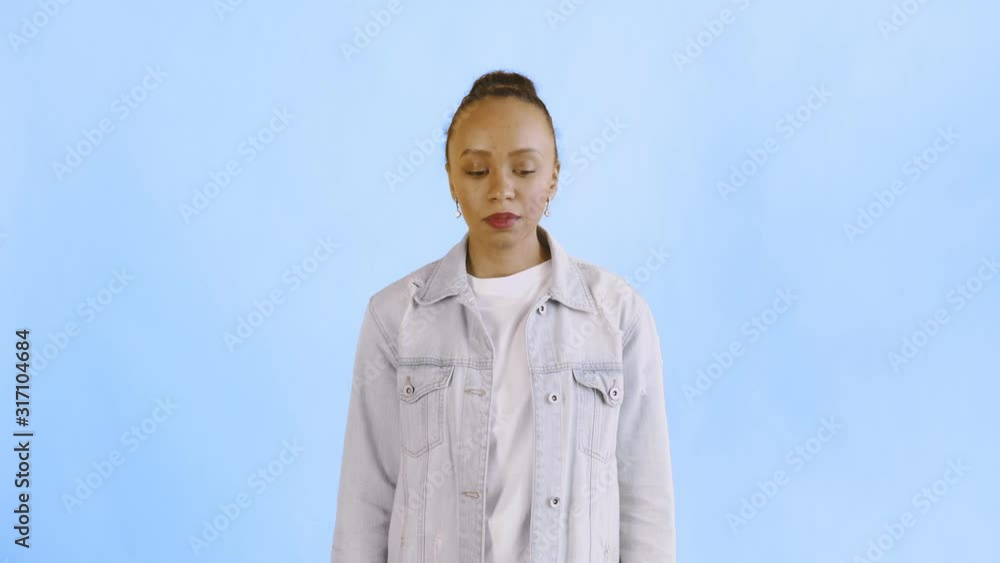 Shoot of african american woman looking at camera on blue background Jean jacket Shoot of african american woman looking at camera on blue background Jean jacket