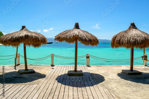 Straw umbrellas on the background of the Sulu Sea. Luxury beach resort in Boracay, The Philippines. photo