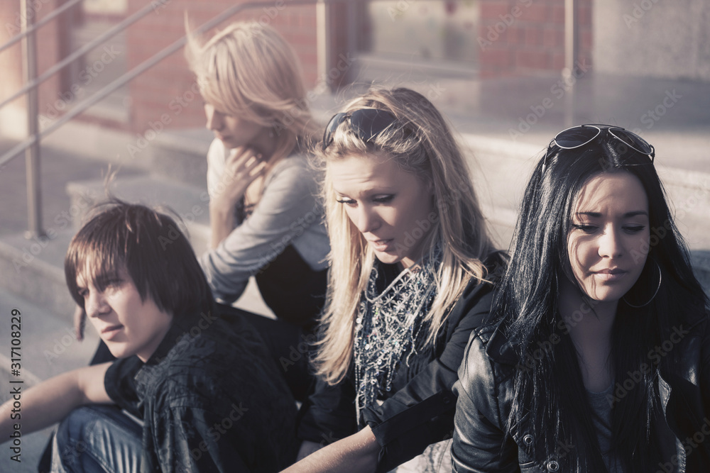 Young fashion people sitting on the steps