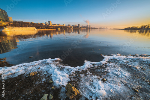 frozen river and cityscape in winter 