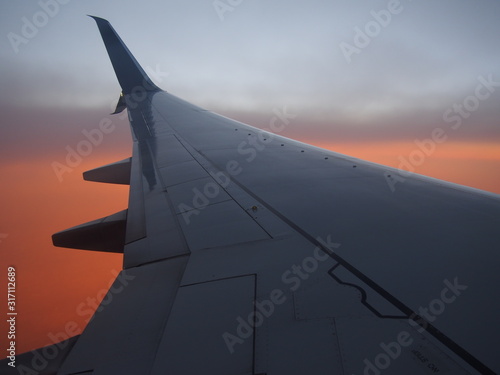 Airplane wing with Sunset Background from Air